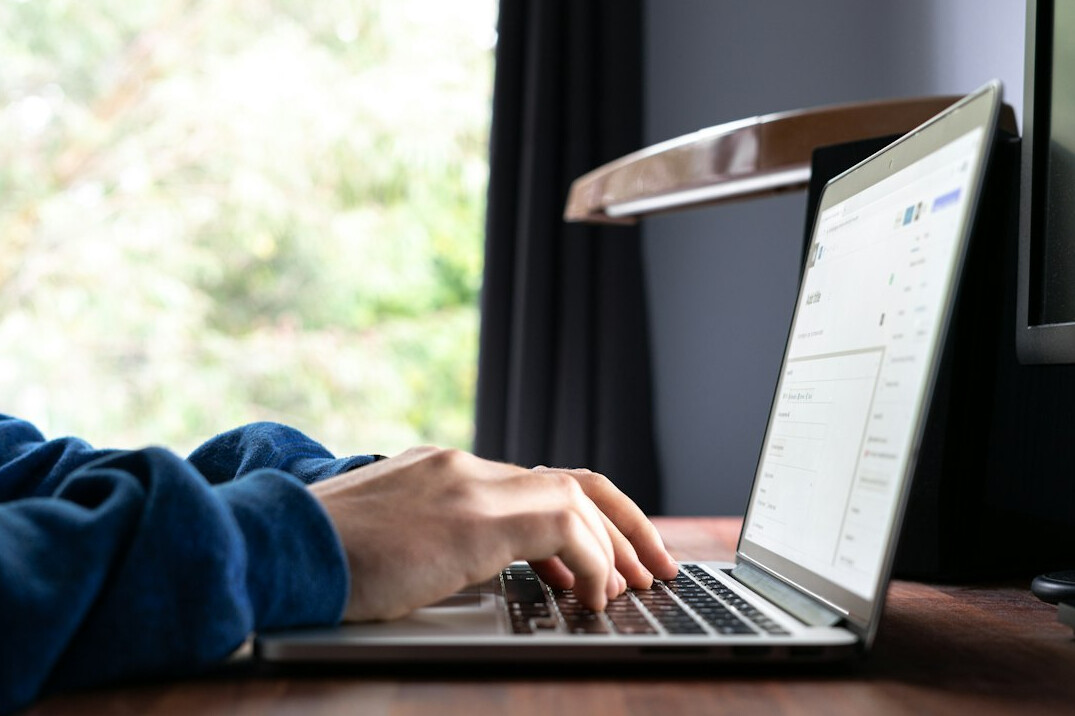 person typing on laptop at night
